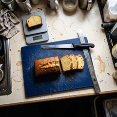 Plumcake tagliato a fette su tagliere con righello e bilancia da cucina