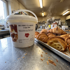 Flechard Burro Chiarificato Liquido Concentrato 7kg su banco da laboratorio con croissant appena sfornati