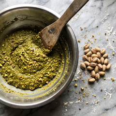 Pesto di pistacchio granuloso con pezzi di pistacchio visibili in ciotola d'acciaio