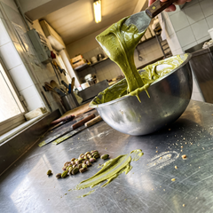 Pasta pistacchio verde primavera in ciotola d'acciaio in laboratorio di gelateria