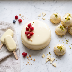 Entremet glassato bianco, stecchi gelato e dolci ricoperti di cioccolato bianco