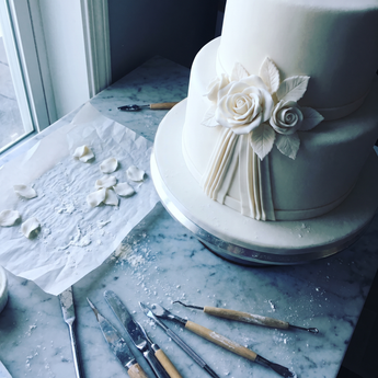 Fiori bianchi per wedding cake: cinque tecniche di modellaggio e il conto del preventivo