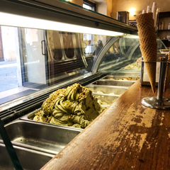 Vetrina della gelateria con la vaschetta di pistacchio variegata in primo piano