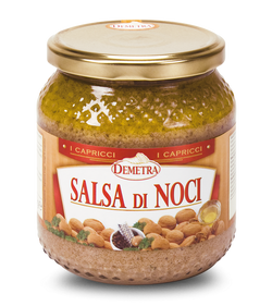 Vaso di vetro Demetra di salsa di noci da 580 ml accanto a un piatto di ravioli conditi