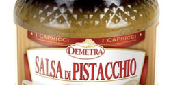 Vaso di vetro Demetra di salsa di pistacchio da 580 ml con crema verde accanto a una pizza gourmet