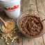 Barattolo Nutella da 3 kg accanto a confezione di granella di arachidi tostate da 1 kg